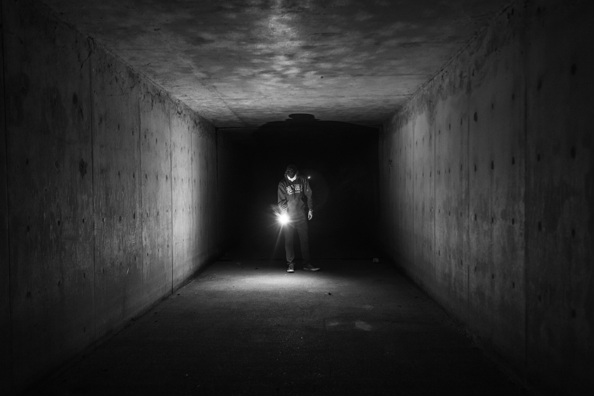 dark corridor, man holding a flashlight, black in